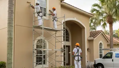 Professional painters painting a home exterior in Kissimmee, FL for residential painting services